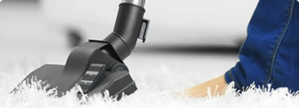 Close-up of a professional vacuuming a white carpet in Bloomingdale.